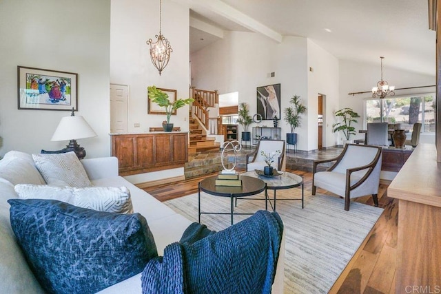 living room featuring beamed ceiling, a chandelier, light hardwood / wood-style floors, and high vaulted ceiling