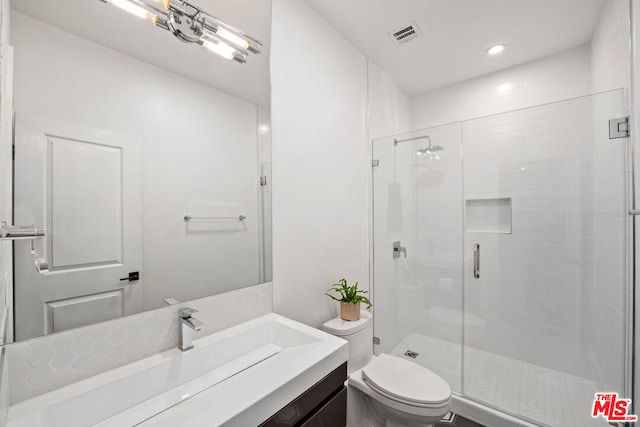 bathroom featuring walk in shower, vanity, and toilet