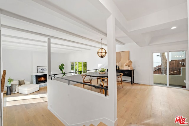 dining room featuring beamed ceiling, light wood-type flooring, and a notable chandelier