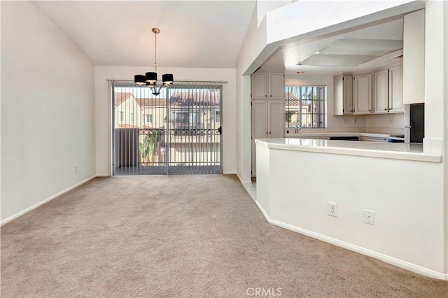 interior space with vaulted ceiling, sink, light colored carpet, and a notable chandelier