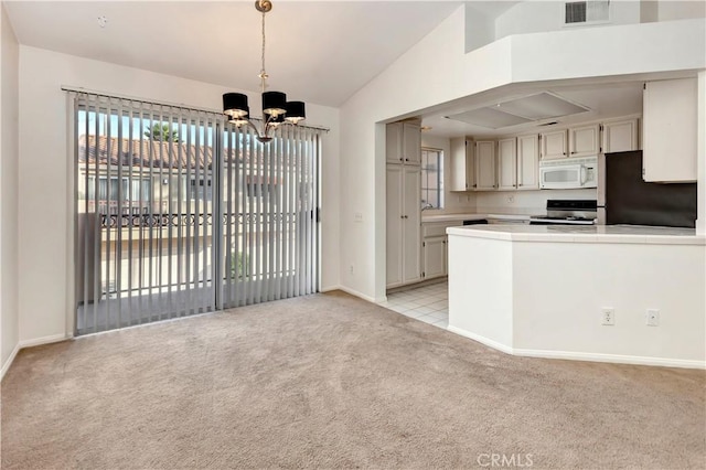 kitchen with light carpet, stainless steel stove, hanging light fixtures, a notable chandelier, and fridge