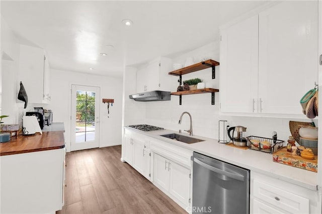 kitchen featuring light wood-type flooring, appliances with stainless steel finishes, sink, and white cabinetry