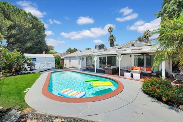 view of swimming pool featuring outdoor lounge area, a yard, a patio, and a shed