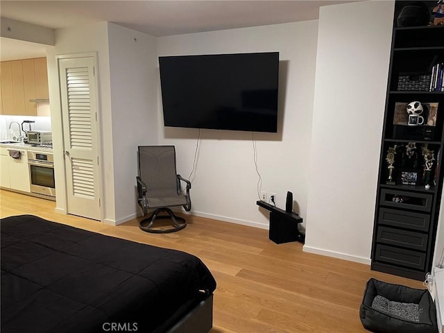 bedroom featuring light wood-type flooring and sink