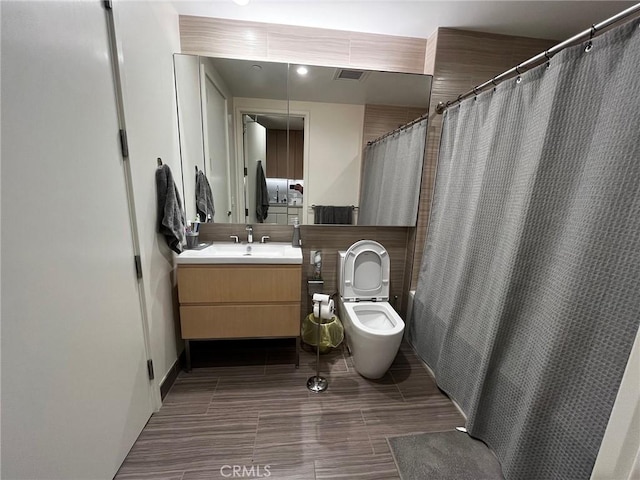 bathroom featuring toilet, vanity, and walk in shower