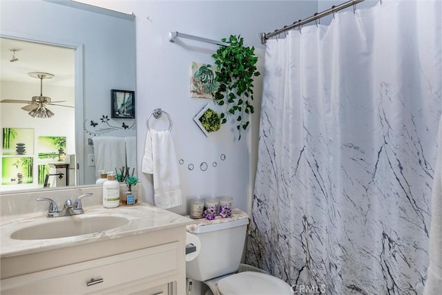 bathroom with toilet, ceiling fan, vanity, and curtained shower