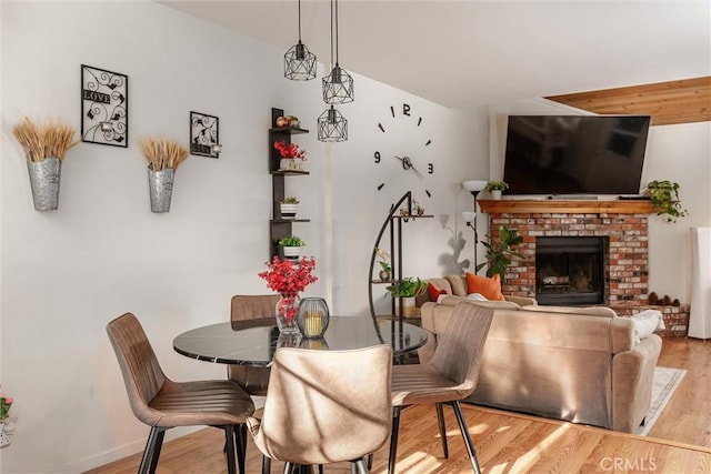 dining room featuring light wood-type flooring and a fireplace