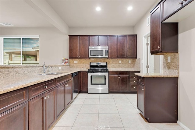 kitchen featuring light tile patterned floors, stainless steel appliances, decorative backsplash, light stone countertops, and sink