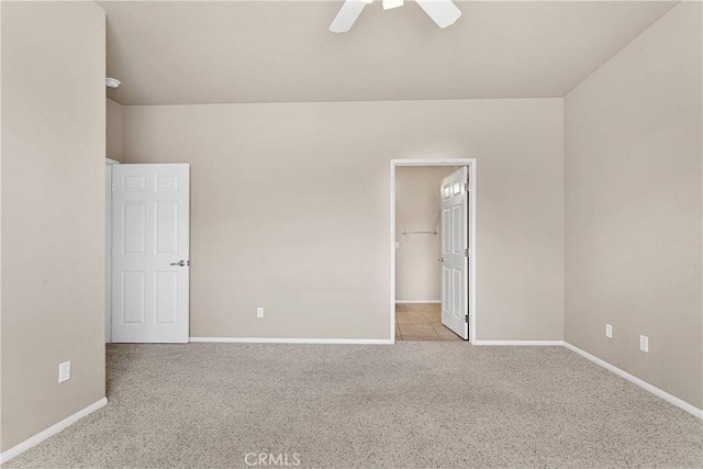 unfurnished bedroom featuring a spacious closet, light colored carpet, a closet, and ceiling fan