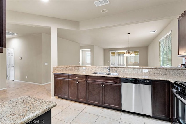 kitchen featuring appliances with stainless steel finishes, a chandelier, pendant lighting, light stone counters, and sink