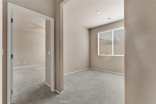 unfurnished room with ceiling fan and light colored carpet