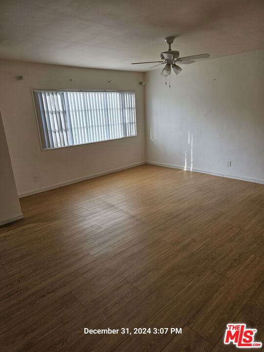 spare room with ceiling fan and wood-type flooring