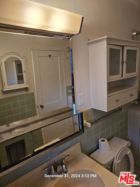 bathroom with tasteful backsplash and sink