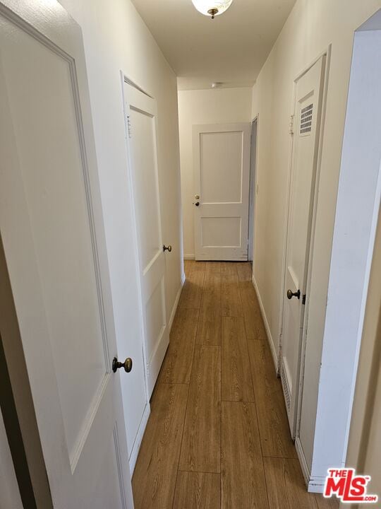 hallway with light hardwood / wood-style floors