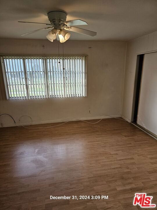 empty room with ceiling fan and wood-type flooring