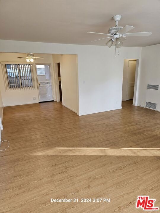 unfurnished room featuring ceiling fan and wood-type flooring