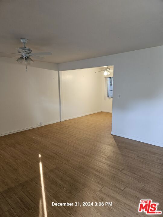 unfurnished room with ceiling fan and wood-type flooring