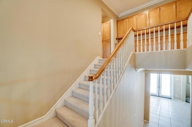 staircase featuring ornamental molding and tile patterned flooring