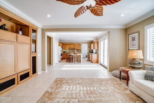 unfurnished living room with crown molding, light tile patterned floors, and plenty of natural light