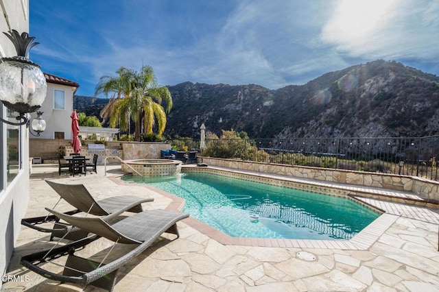 view of pool with an in ground hot tub, a mountain view, and a patio