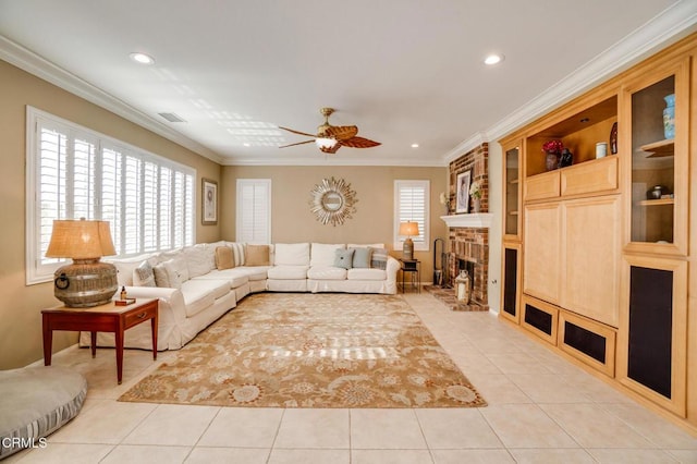 tiled living room with a brick fireplace, ceiling fan, and ornamental molding