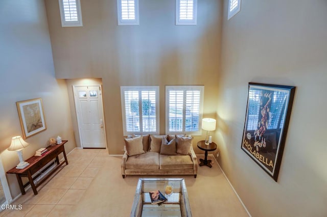 living room featuring a towering ceiling and light tile patterned flooring