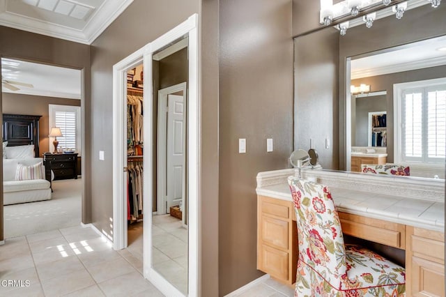 bathroom featuring tile patterned floors, a wealth of natural light, crown molding, and vanity