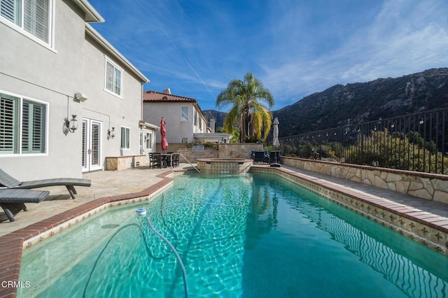 view of pool featuring a mountain view, an in ground hot tub, french doors, and a patio