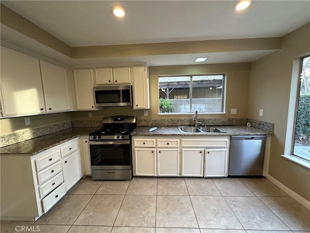 kitchen with plenty of natural light, sink, white cabinetry, and stainless steel appliances