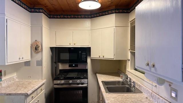 kitchen featuring wooden ceiling, sink, white cabinets, and stainless steel gas range oven