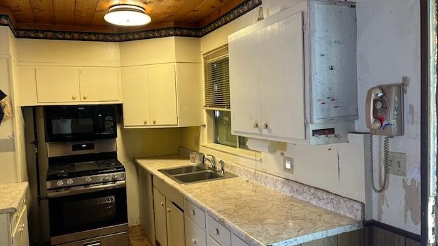 kitchen with stainless steel gas stove, sink, white cabinets, and wood ceiling