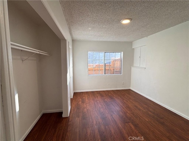 unfurnished bedroom featuring a closet, dark hardwood / wood-style flooring, and a textured ceiling