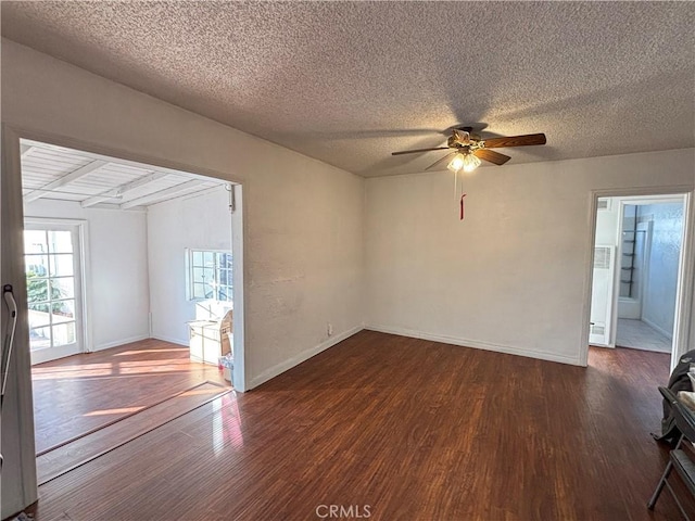 unfurnished room featuring ceiling fan, dark wood-type flooring, and a textured ceiling