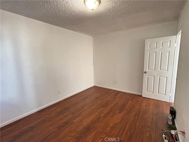 unfurnished room with dark hardwood / wood-style floors and a textured ceiling