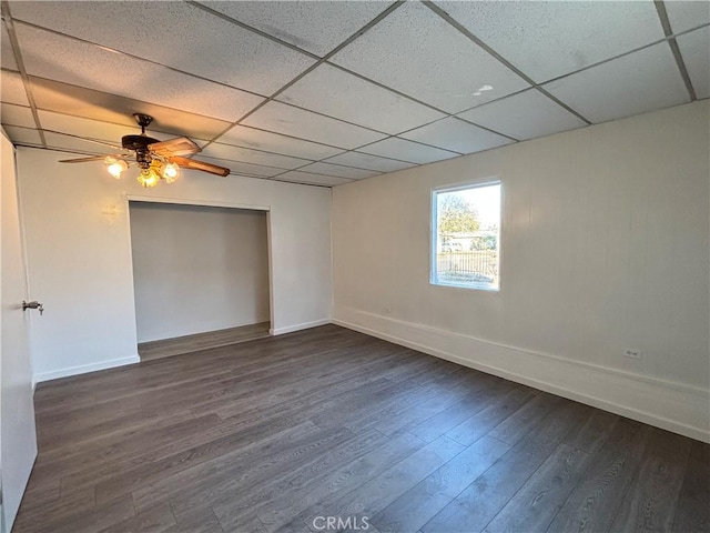 spare room featuring dark wood-type flooring, a paneled ceiling, and ceiling fan