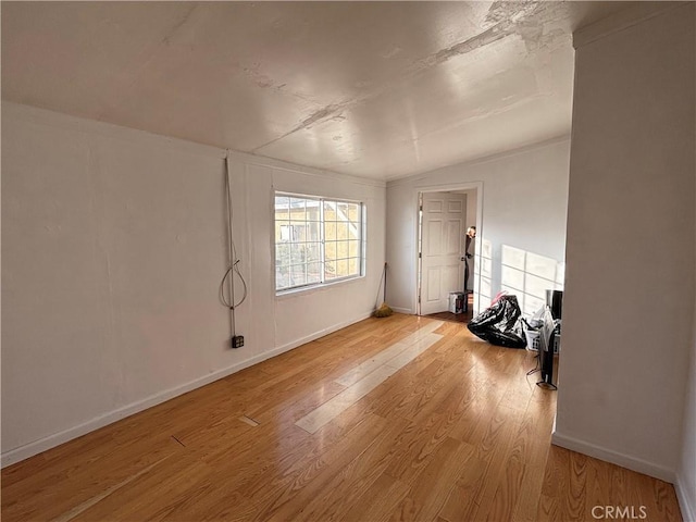 empty room featuring lofted ceiling and light hardwood / wood-style floors