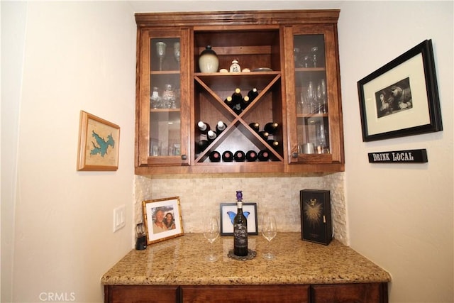 bar featuring tasteful backsplash and light stone counters