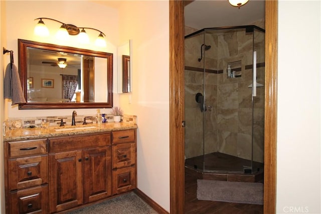 bathroom with ceiling fan, vanity, and an enclosed shower