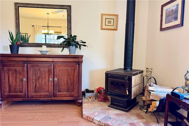 details featuring an inviting chandelier, a wood stove, and hardwood / wood-style flooring