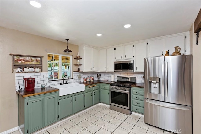 kitchen with white cabinetry, stainless steel appliances, backsplash, light tile patterned flooring, and sink