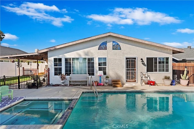 rear view of house with a pool with hot tub and a patio area