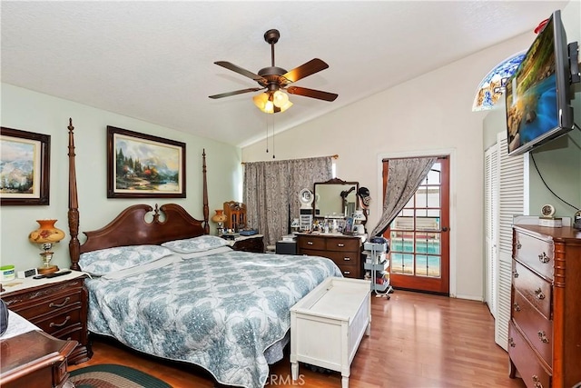 bedroom with ceiling fan, lofted ceiling, and light wood-type flooring