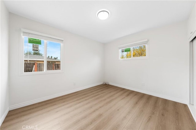 empty room featuring a healthy amount of sunlight and light hardwood / wood-style flooring