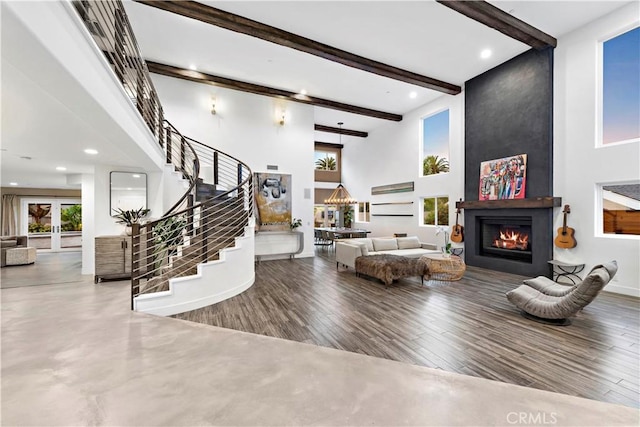 living room featuring beamed ceiling and a high ceiling