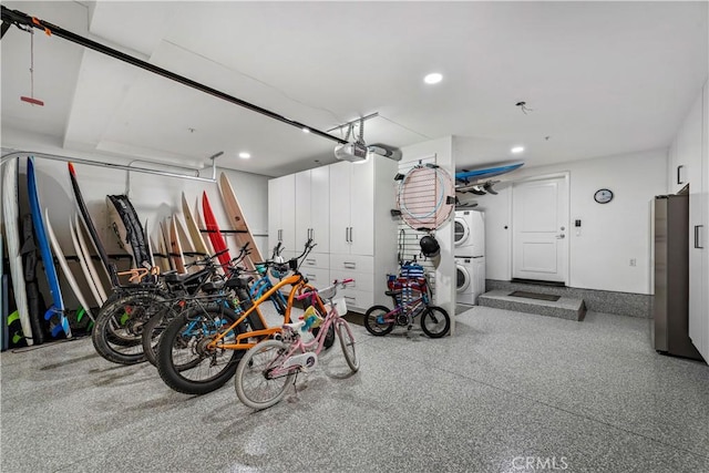 garage featuring stacked washer and dryer, stainless steel fridge, and a garage door opener