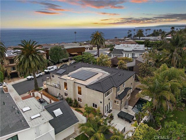 aerial view at dusk featuring a water view