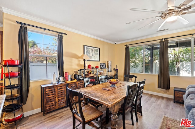 dining room featuring ornamental molding, light hardwood / wood-style floors, and plenty of natural light