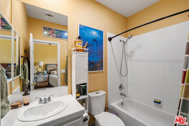 full bathroom featuring toilet, vanity, and tiled shower / bath