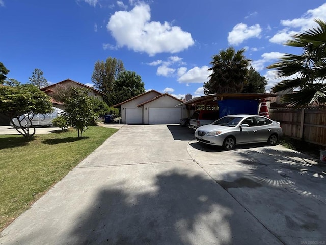 view of front of home featuring a front lawn, a carport, and a garage