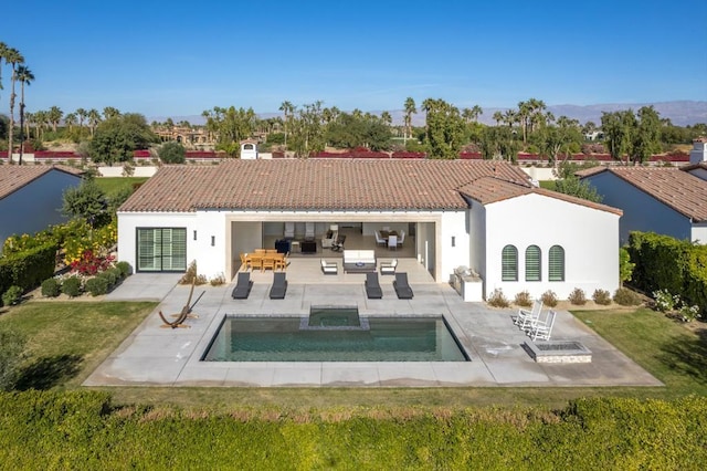 back of house featuring a patio area, outdoor lounge area, a hot tub, and a yard